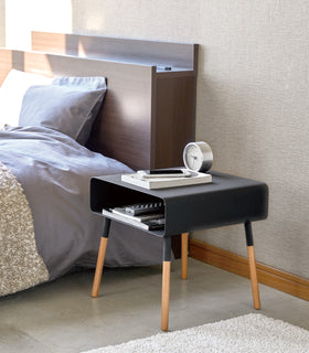 Side view of black Storage Table holding phone, books and clock in bedroom by Yamazaki Home. view 9