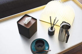 Aerial view of black Tissue Case on table next to book light, cup, and décor pieces by Yamazaki Home. view 11