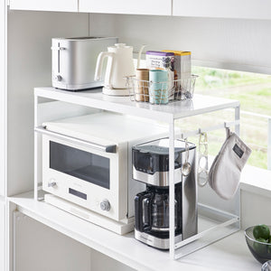 White Yamazaki Home Kitchen Appliance Rack With Steel Side Panel on a countertop with various appliances as well as kitchen tools hung on it