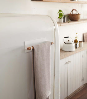Magnetic Dish Towel Hanger holding dish towel on kitchen fridge by Yamazaki Home. view 2