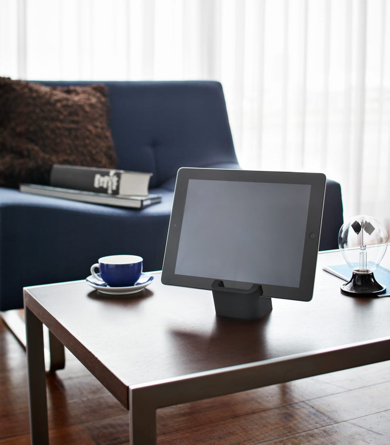 Black Tablet Stand holding tablet on coffee table by Yamazaki Home.