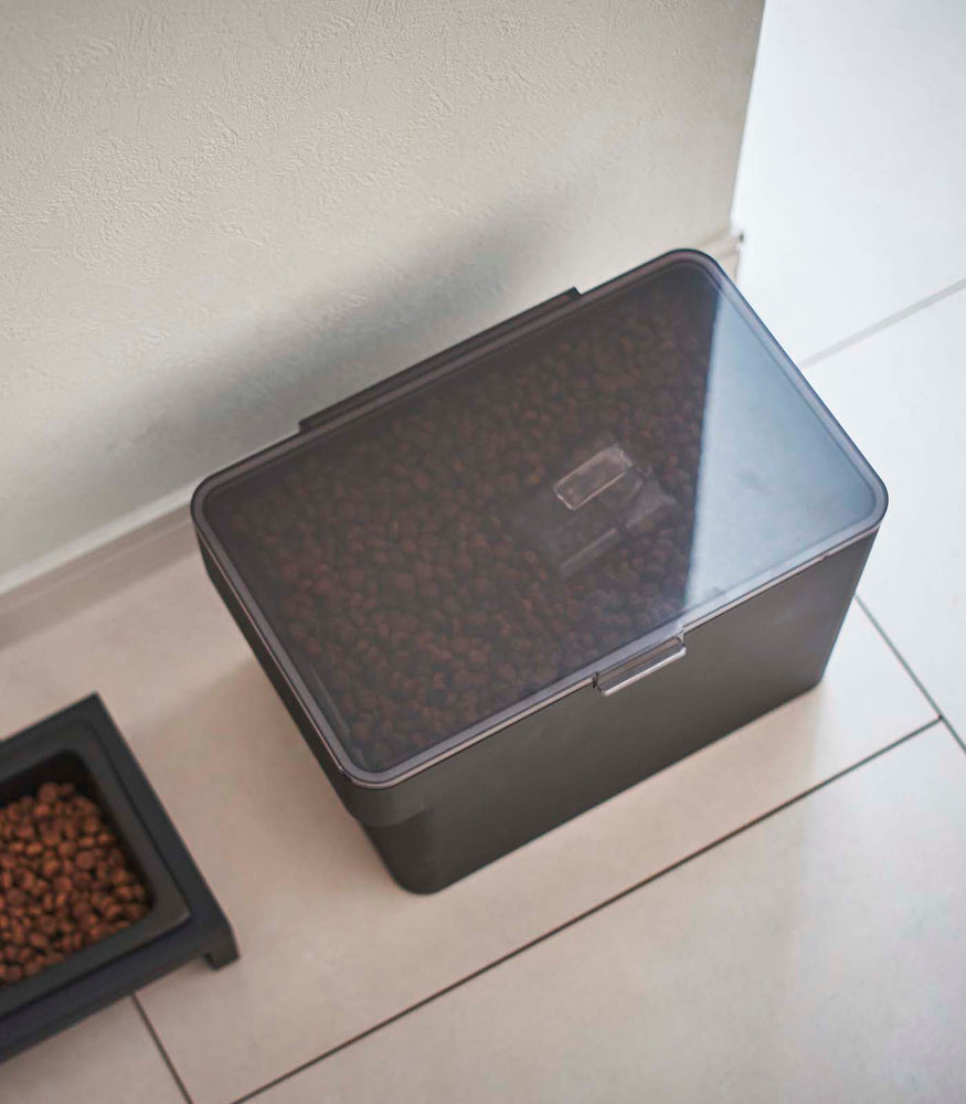 View 25 - Aerial view of black Airtight Food Storage Container holding pet food next to black Pet Food Bowl by Yamazaki Home.