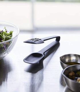 Close up front view of black Slotted Tongs on kitchen counter by Yamazaki Home. view 20