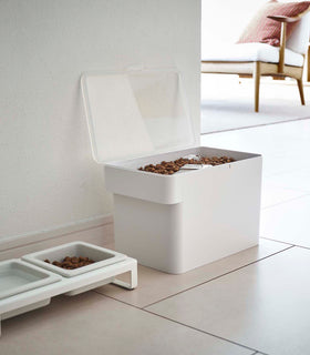 White Airtight Food Storage Container open and holding pet food next to white Pet Food Bowl by Yamazaki Home. view 17