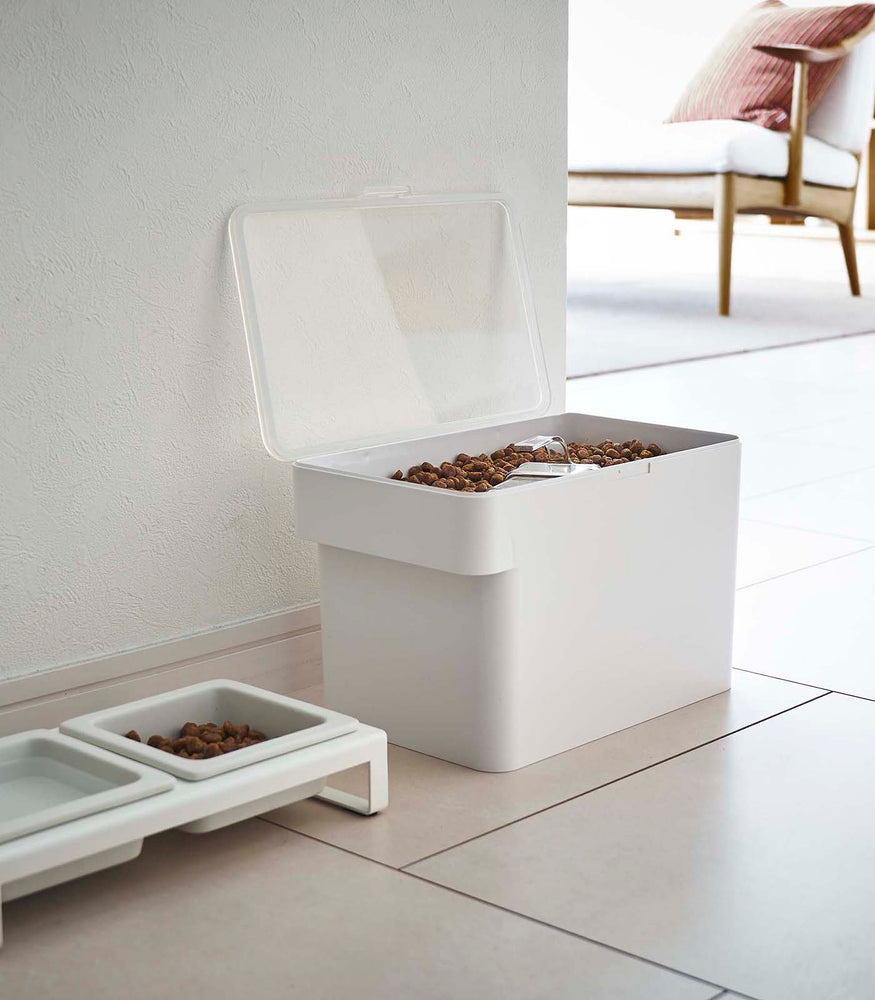 View 18 - White Airtight Food Storage Container open and holding pet food next to white Pet Food Bowl by Yamazaki Home.