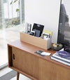 White Desk Organizer holding office items on tv stand by Yamazaki Home.