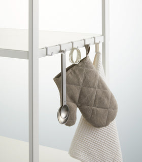 Close up view of white Storage Rack hooks hanging kitchen items on white background by Yamazaki Home. view 11