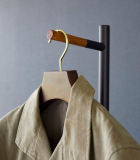 Close up of the top of a black Yamazaki Coat Rack with a jacket hung on it view 12