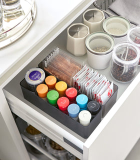 Two deep stackable clear organizers in black are placed in a kitchen drawer, organizing bins and pouches of spices, neatly placed next to each other. view 56