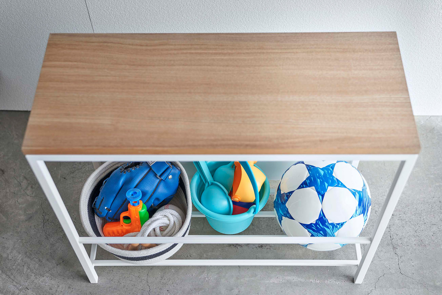 View 8 - Close up view of white Yamazaki Discreet Entryway Storage Shelf with toys and balls inside