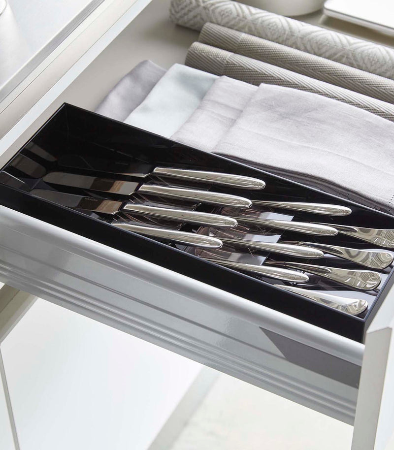 Black Cutlery Storage Organizer holding silverware in kitchen drawer by Yamazaki Home.