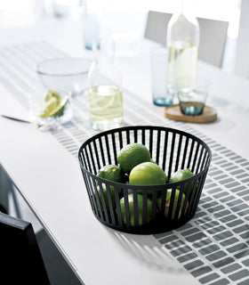 Black Fruit Basket holding limes on dining room table by Yamazaki Home. view 17