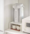 White Yamazaki Home Stackable Countertop Shelf with cups below and a water dispenser above