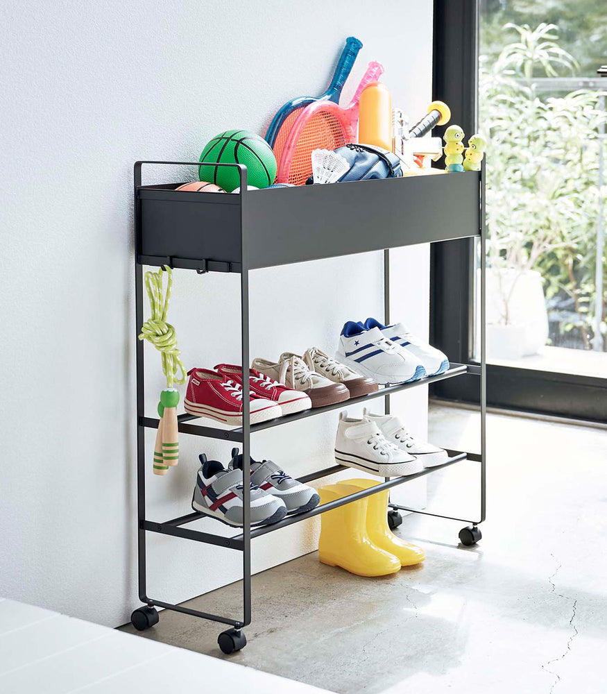 View 12 - Black Yamazaki Entryway Organizer with shoes and toys on it