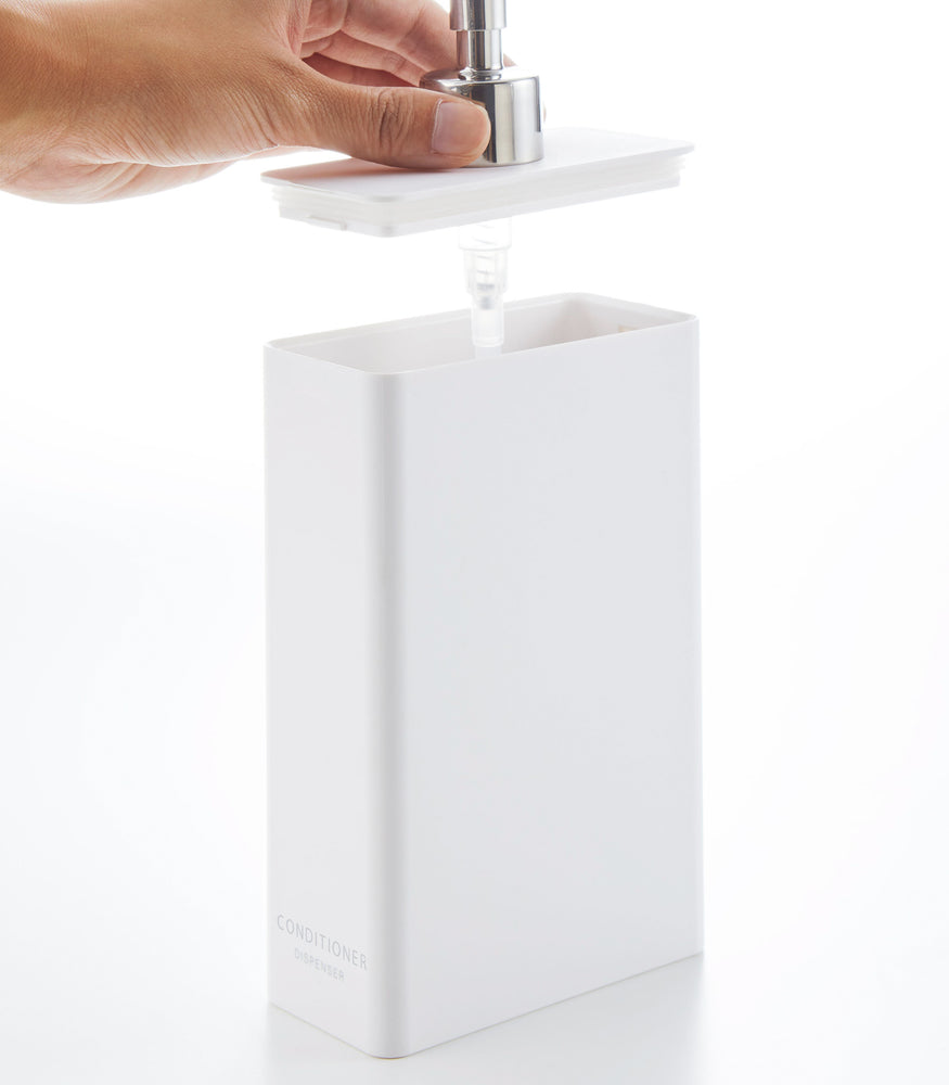 View 13 - Side view of white Conditioner Dispenser with top off on white background by Yamazaki Home.