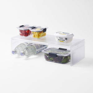Yamazaki Home Expandable Refrigerator Riser Shelf with props, set against a white background.