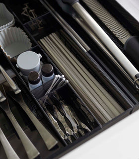 Close up aerial view of black Expandable Cutlery Storage Organizer holding utensils by Yamazaki Home. view 23