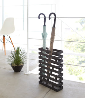 Black Shoe Rack in entryway holding heels and sneakers by Yamazaki home. view 18