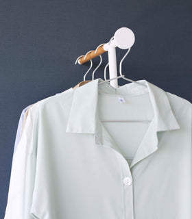 Frontal view of collared shirts hung on white Yamazaki Home Clothes Steaming Leaning Pole Hanger view 7