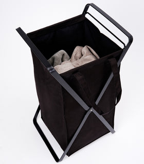 Small Laundry Hamper with Cotton Liner by Yamazaki Home in black on a white background with towels inside. view 9