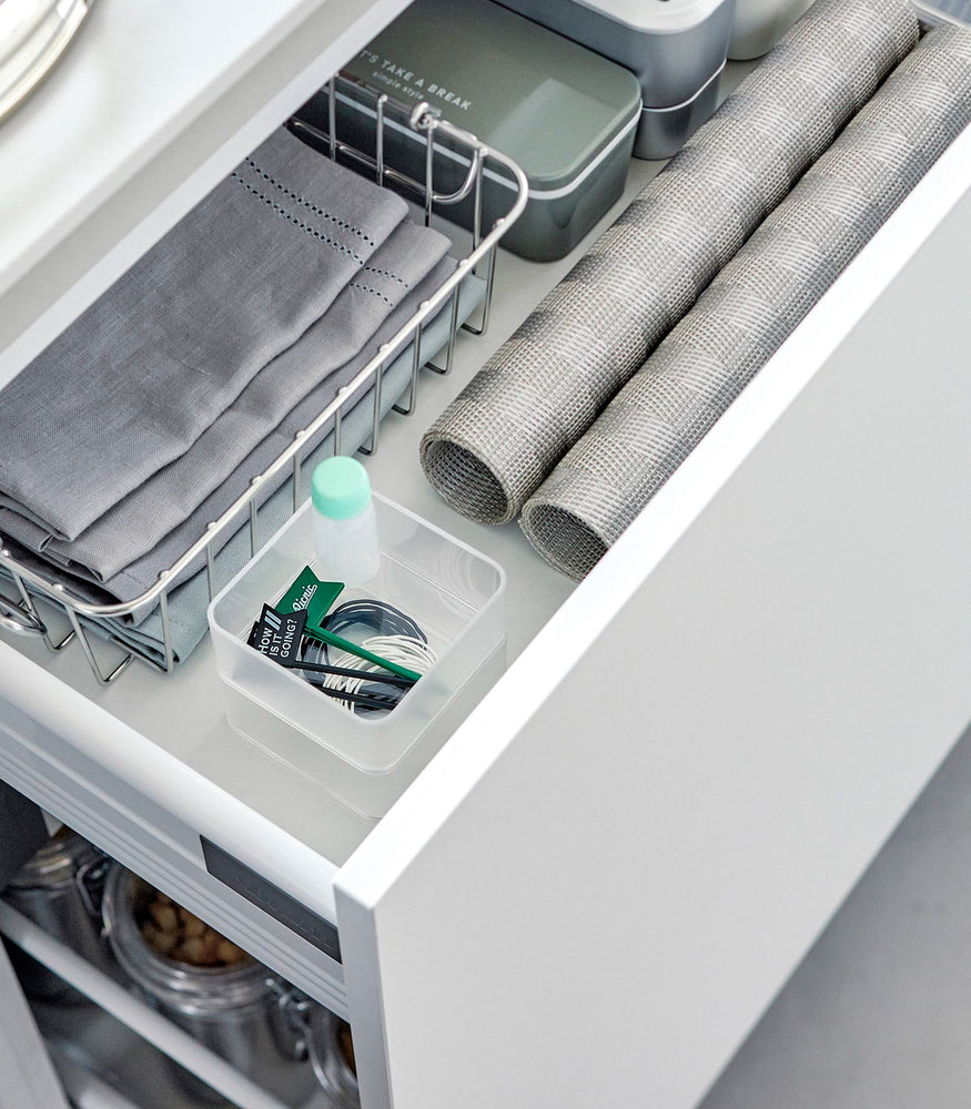 View 2 - Two small stackable clear organizers are placed in a kitchen drawer, one on top of the other, showcasing how they can be neatly stacked.