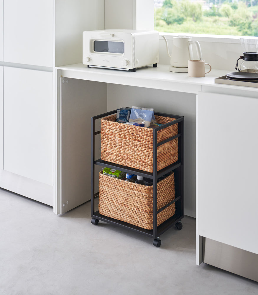 View 10 - Two-level black steel storage cart with casters is shown in an opening of a recessed cabinet. Cart houses storage bins on both levels. One side of the cart has a wall to hide storage.