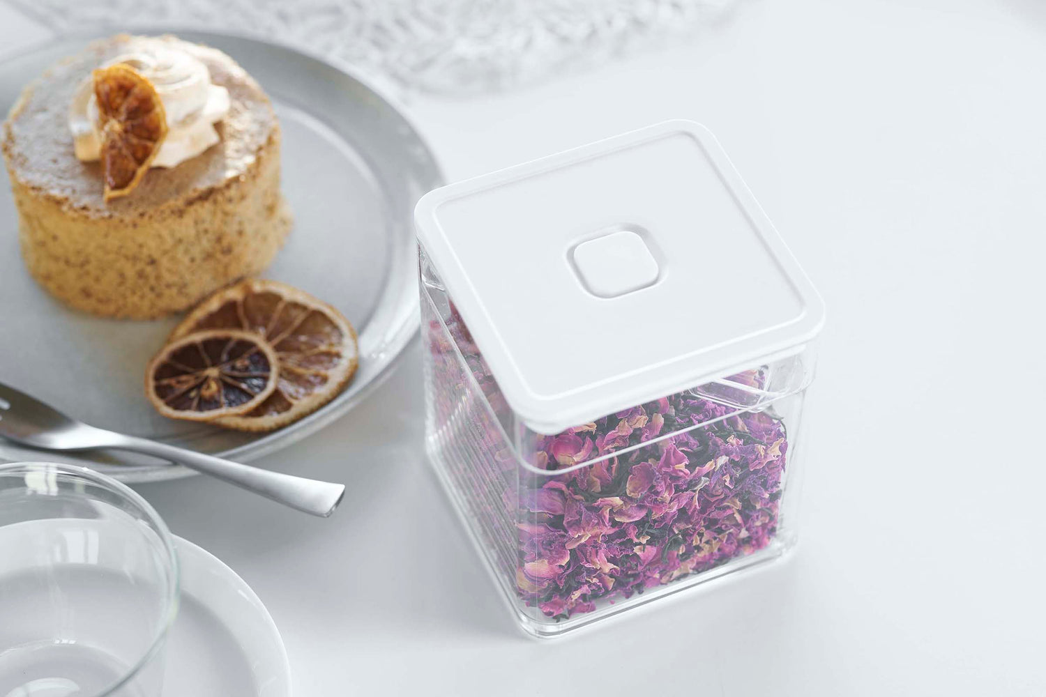 View 5 - Close up view of white Vacuum-Sealing Food Container w. Spoon holding tea leaves on countertop  by Yamazaki Home.