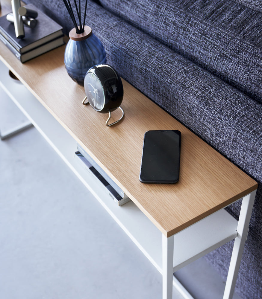 View 22 - Close up of white Yamazaki Home Long Console Table - Shelf  with a phone and clock on it