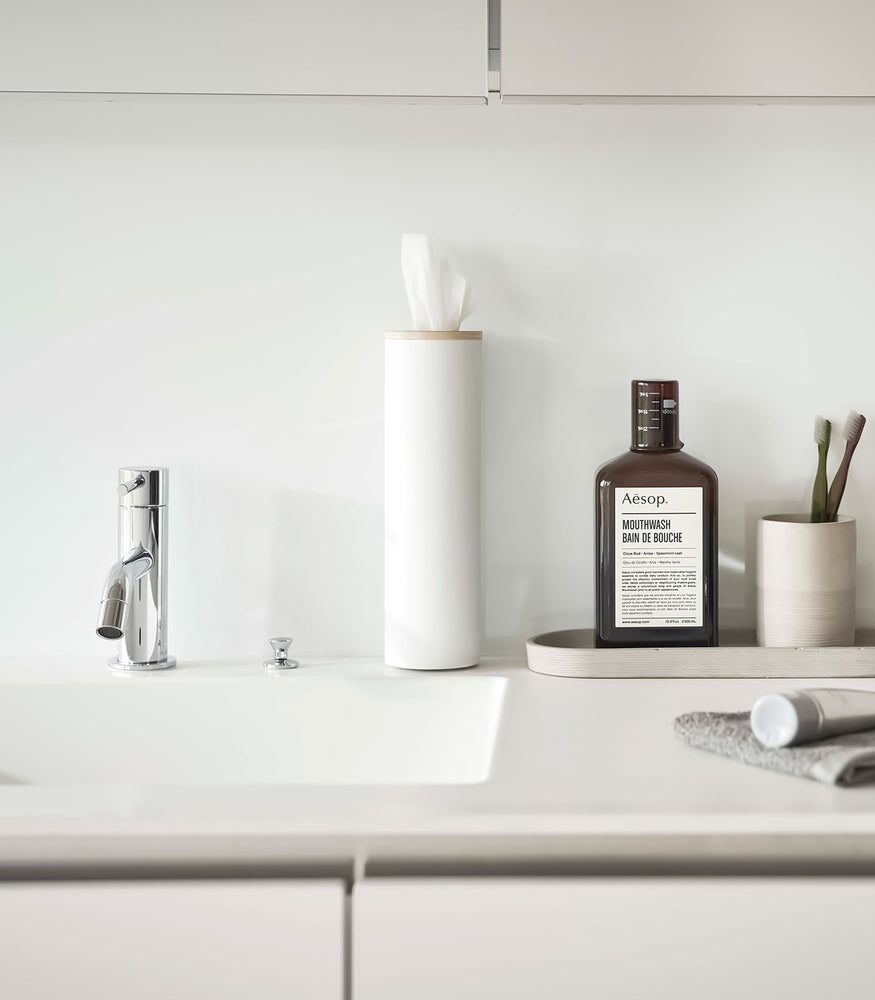 View 8 - Small white Yamazaki Home Round Tissue Case on a bathroom sink counter