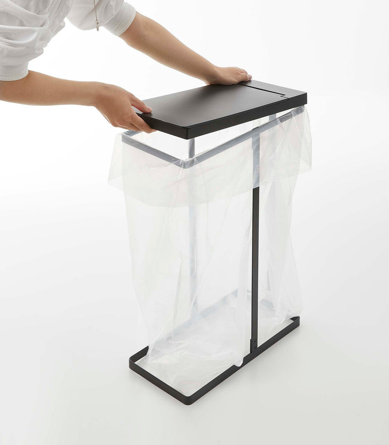 Black Yamazaki Home Lidded Garbage Bag Holder and lid being installed