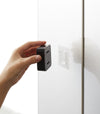 Black Yamazaki Home Traceless Adhesive Towel Holder being placed on the adhesive hook