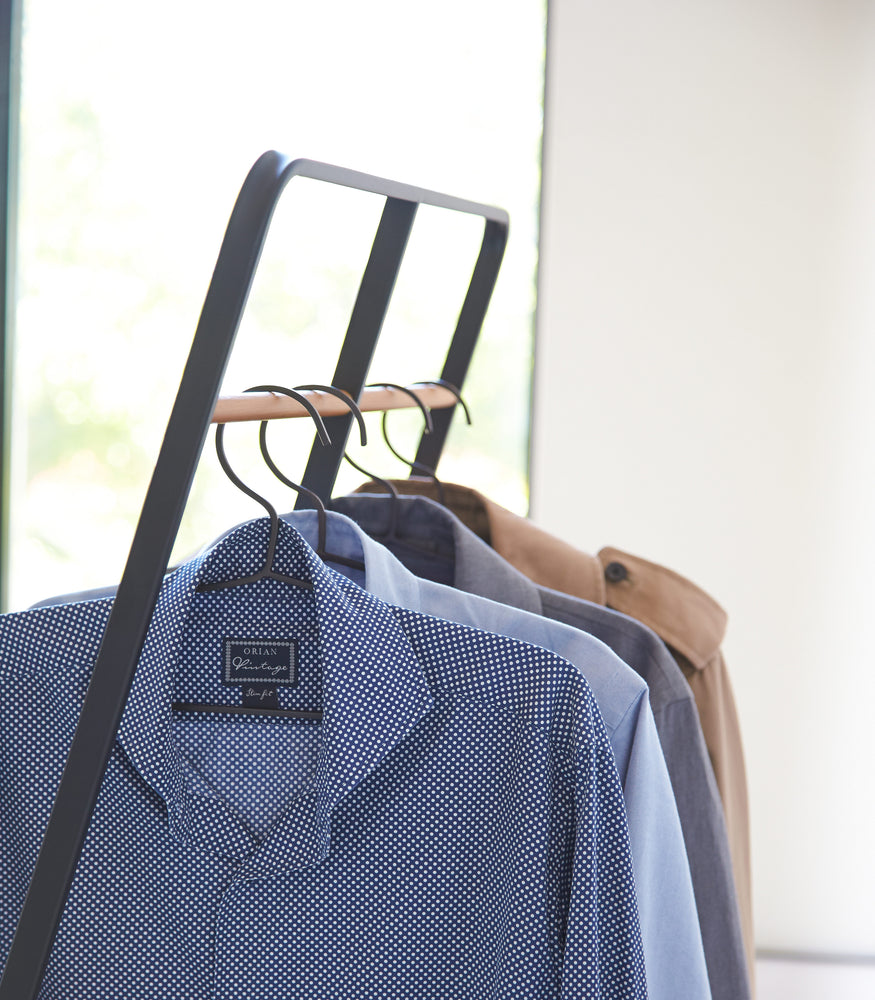 View 10 - Side view of black 2-level Coat Rack holding shirts by Yamazaki Home.