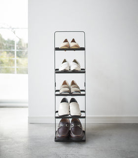 Front view of entryway black Shoe Rack holding shoes by Yamazaki home. view 21