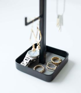 Close up of black Yamazaki Home Tree Accessory Stand showing rings and a watch view 12