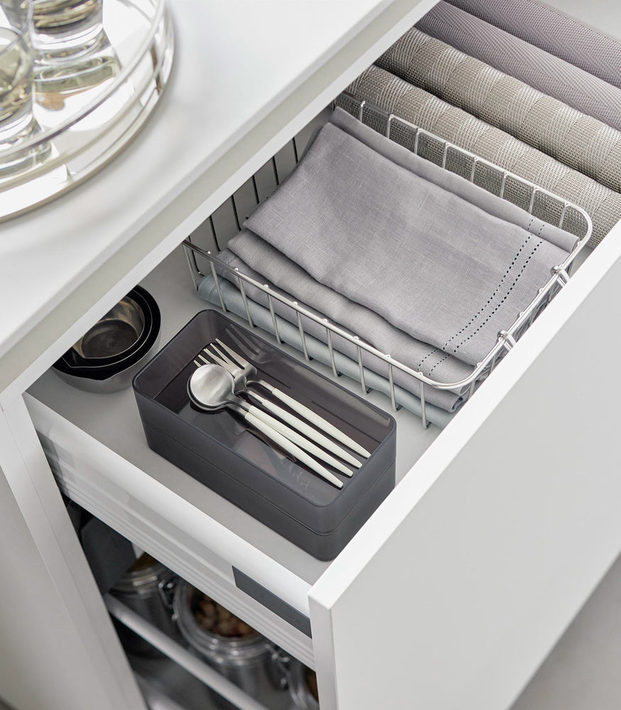 View 23 - Two medium stackable clear organizers in black are placed in a kitchen drawer, organizing cutlery and wine openers, neatly stacked together.