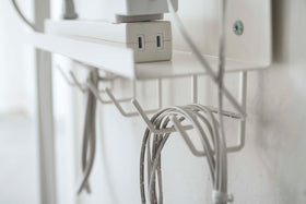 Close up side view of white Wall-Mount Cable and Router Storage Rack's hooks holding cord by Yamazaki Home. view 6