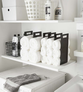 Black Towel Storage Organziers holding towels on laundry room shelf by Yamazaki Home. view 8