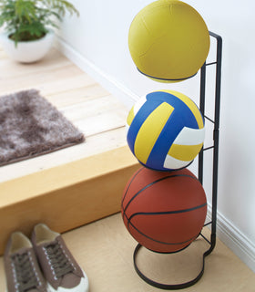 Black Sport Ball Stand displaying sport balls in entryway by Yamazaki Home. view 3