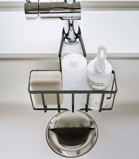 Close up top-down view of a Yamazaki Home black Faucet-Hanging Sponge Caddy in a sink view 12