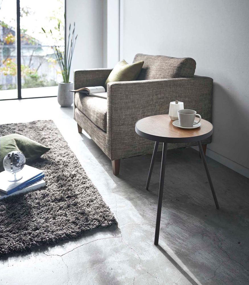 View 9 - White Side Table by Yamazaki Home in a living room holding a cup of coffee and a sugar canister.