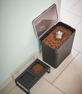 Aerial view of open black Airtight Food Storage Container holding pet food next to black Pet Food Bowl by Yamazaki Home. view 40