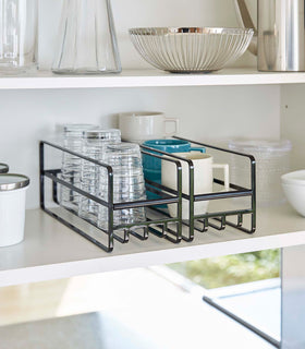 2 Yamazaki Home black Glass and Mug Cabinet Organizers on a shelf beside plates view 10
