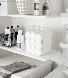 White Towel Storage Organizer displaying towels on laundry room shelf by Yamazaki Home. view 3