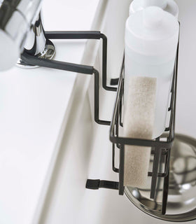Close up side view of Yamazaki Home black Faucet-Hanging Sponge Caddy to a kitchen sink view 13