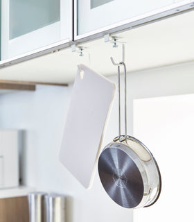 White Undershelf Hangers holding pan and cutting board in kitchen by Yamazaki Home. view 4