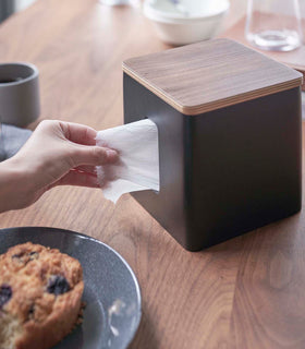 Person removing paper from black toilet paper holder on tabletop by Yamazaki Home. view 12