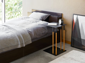 Black C Side Table displaying book and clock in bedroom by Yamazaki Home. view 7
