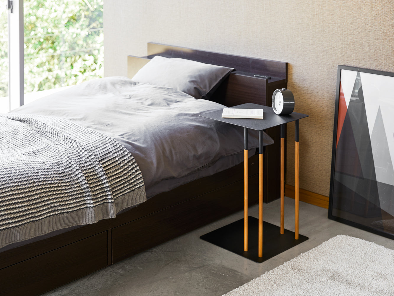 View 7 - Black C Side Table displaying book and clock in bedroom by Yamazaki Home.