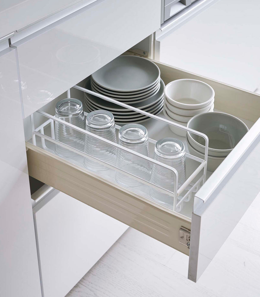 View 6 - Yamazaki Home white Glass and Mug Cabinet Organizer in a drawer beside plates and bowls