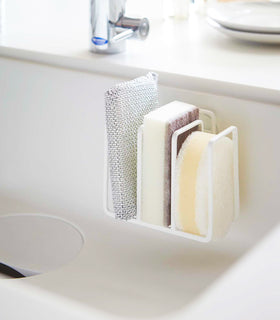 White Sponge Holder containing sponges in kitchen sink by Yamazaki Home. view 3